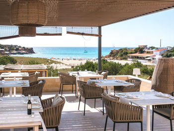 Empty chairs and tables at beach