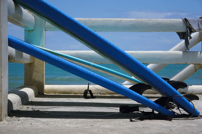 Close-up of metal railing against blue sky