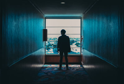 Rear view of man standing in corridor of building