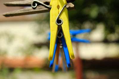 Close-up of clothespins hanging on rope