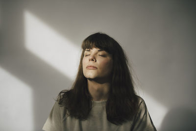 Portrait of a beautiful young woman against wall