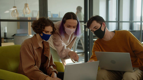 Female friends using laptop at home