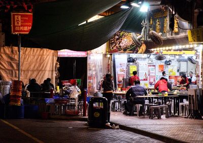 People at market stall at night