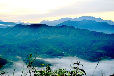 Scenic view of mountains against cloudy sky