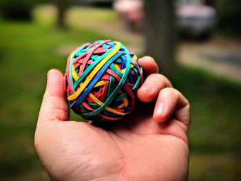 Close-up of person holding multi colored human hand