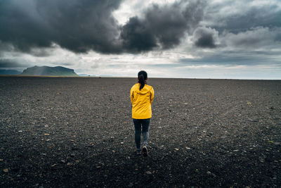 Rear view of woman walking on beach