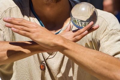 Midsection of man holding crystal ball