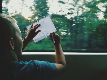 Close-up portrait of boy holding paper outdoors