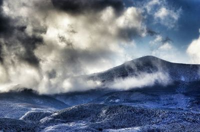 Scenic view of mountains against cloudy sky