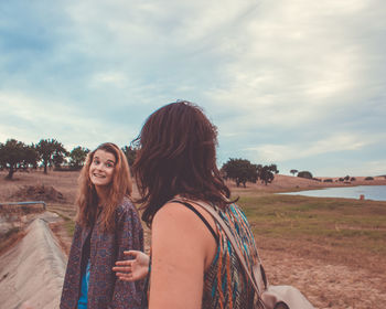 Beautiful woman standing on land against sky