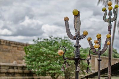 Close-up of trident in temple against sky.