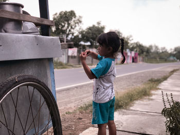 Cute girl standing by vendor stall on street