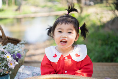 Portrait cute girl sitting at park