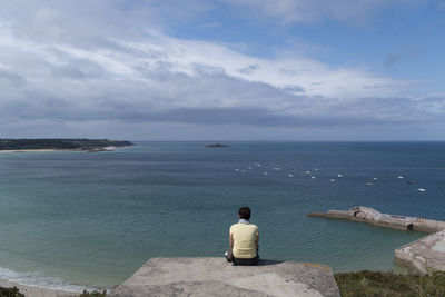 Rear view of people looking at sea against sky