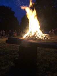 Bonfire on field against sky at night