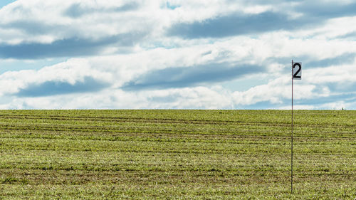 Golf course countryside field with flag and clear blue sky