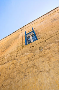 Low angle view of arrow sign against clear blue sky