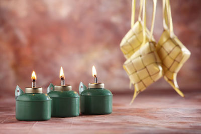 Close-up of decoration and illuminated oil lamp on table