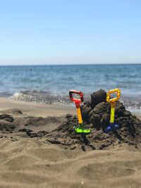 Toy on beach against clear sky