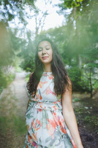 Happy mixed race japanese woman in park. eyes closed, defocused, dreamy bokeh