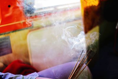 Midsection of man holding incense