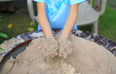 Midsection of girl holding sand