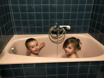 Portrait of brother and sister in bathtub at home