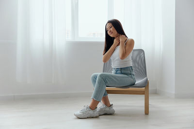 Portrait of young woman sitting on sofa at home