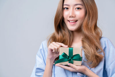 Portrait of a smiling young woman against white background