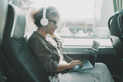 Young woman using laptop while sitting in car