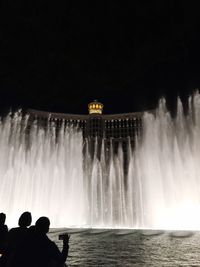 Panoramic view of illuminated fountain against clear sky at night