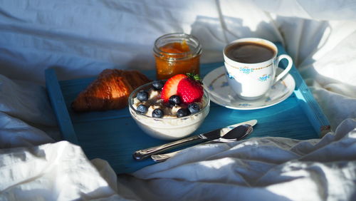 Breakfast in bed mediterranean hotel home. coffee, croissant, healthy diet oatmeal berries, jam