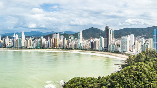 Scenic view of river by buildings against sky