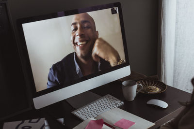 Smiling businessman on computer screen during video call