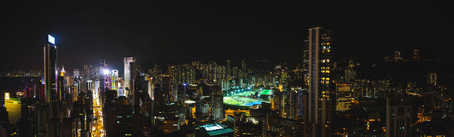 Illuminated cityscape against sky at night