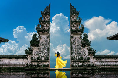 Woman by historic building against sky