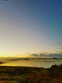 Scenic view of field against clear sky during sunset