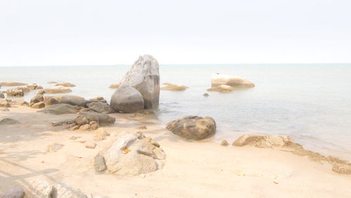 Rocks on beach against clear sky