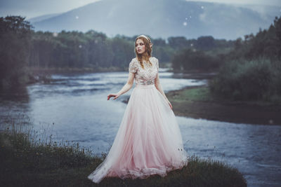 Full length of a young woman standing in water