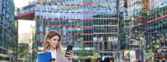 Portrait of young woman standing in city