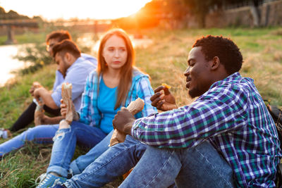 Smiling friends using mobile phone