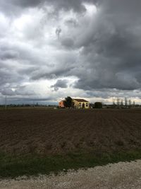 Scenic view of field against cloudy sky