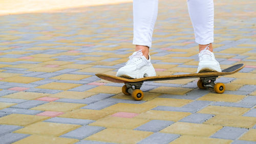 Low section of man skateboarding on street