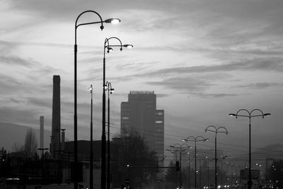 Low angle view of factory against sky during sunset