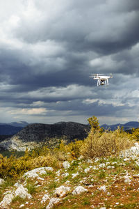 Airplane flying over mountains against sky