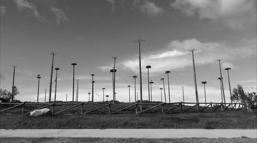 Street lights by road against sky