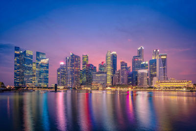 Illuminated city buildings against sky at night