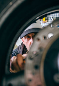 Mature mechanic repairing motorcycle in garage