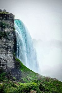 Scenic view of waterfall against sky