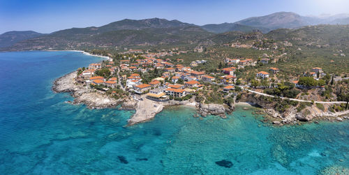 Aerial view of city by sea against sky